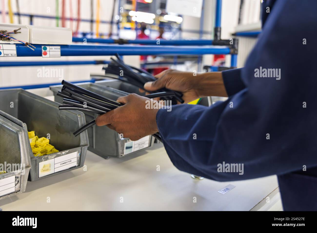 cablaggio automatico pannello di fabbrica, fabbrica di cablaggi elettrici per auto, tubi e connettori per cassetti, operaio afroamericano Foto Stock