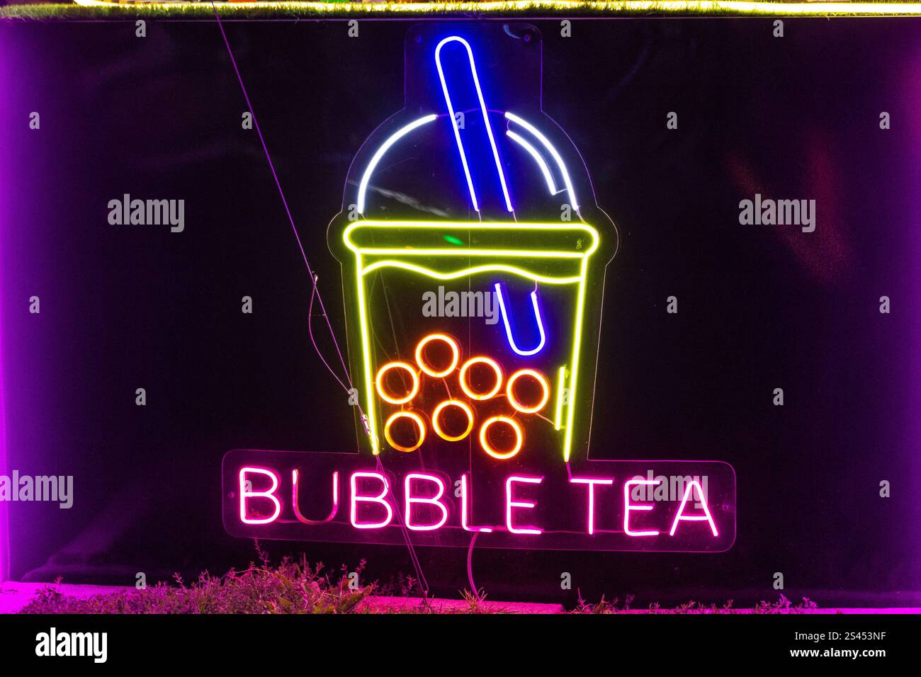 Insegna del tè al neon, insegna della lampada colorata che si illumina nella finestra del caffè Foto Stock