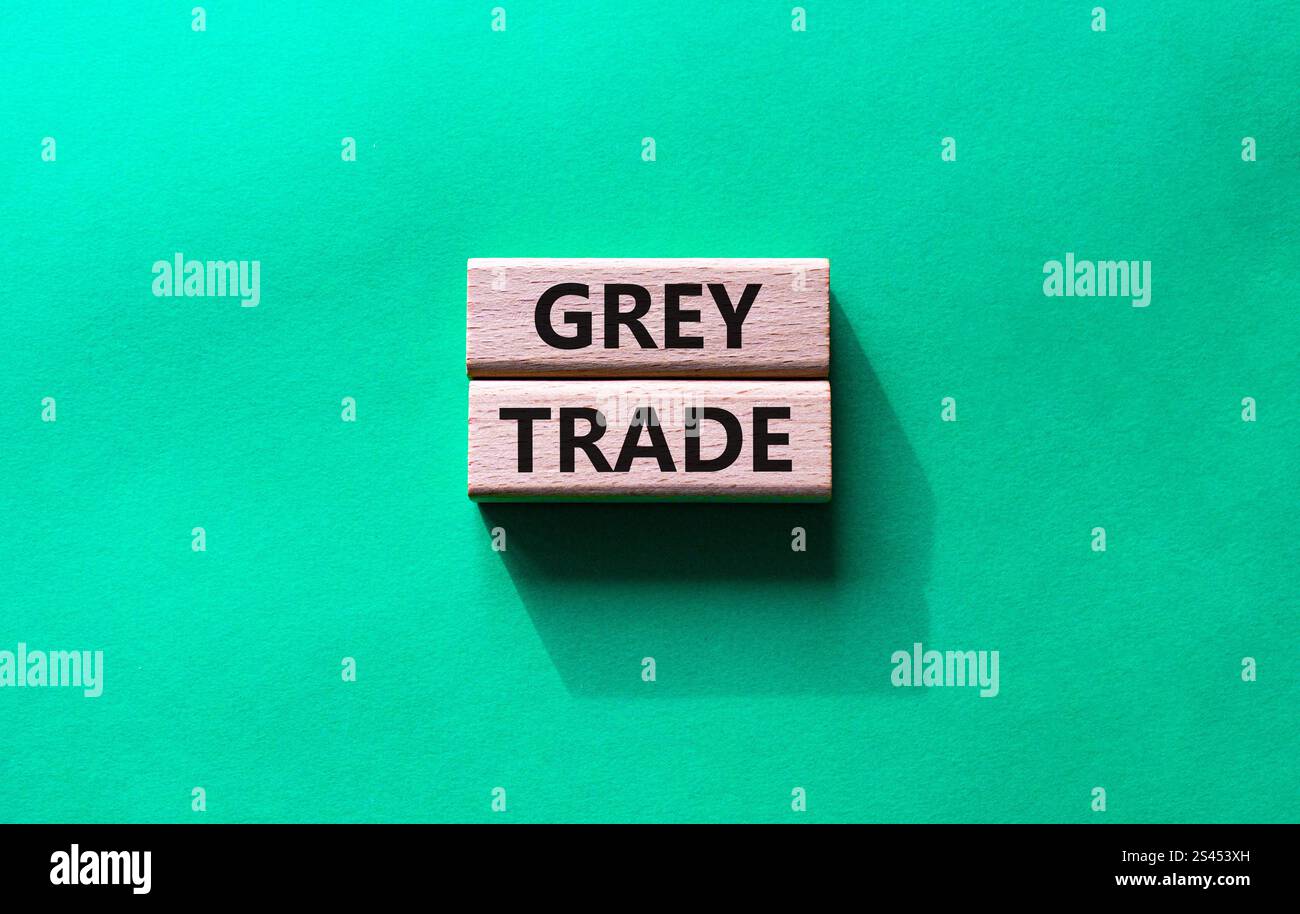 Simbolo commerciale grigio. Blocchi di legno con parole "commercio grigio". Bellissimo sfondo verde. Business e concetto di commercio grigio. Copia spazio. Foto Stock