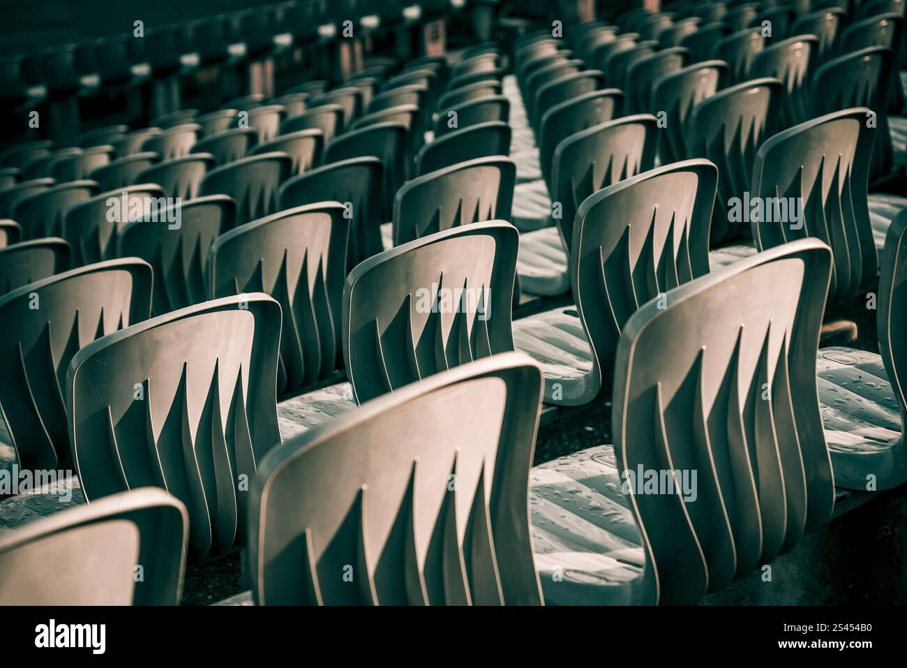 Settore all'arena dello stadio, file di sedili grigi in plastica dell'anfiteatro, giornata nuvolosa Foto Stock