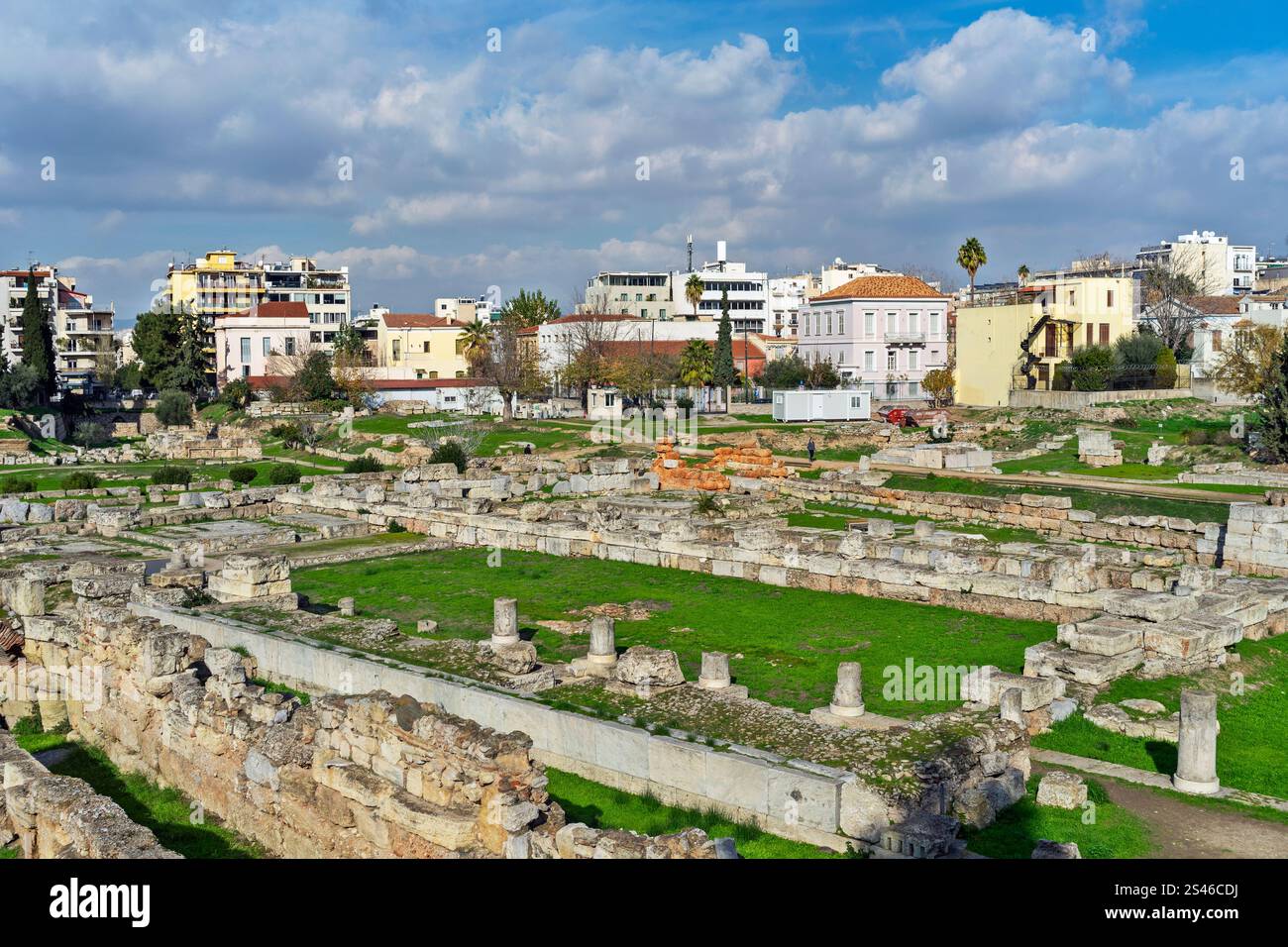 Sito archeologico di Kerameikos ad Atene, in Grecia, che mostra antiche rovine circondate da moderni edifici urbani sotto un cielo parzialmente nuvoloso Foto Stock