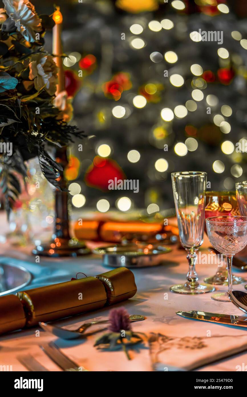 Elegante tavolo per le feste natalizie con decorazioni natalizie e luci bokeh (colori caldi) Foto Stock