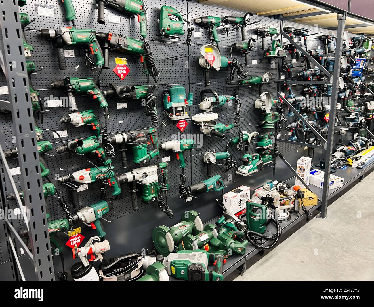 Kiev, Ucraina - 10 gennaio 2025: Un assortimento di utensili elettrici con trapani, smerigliatrici e levigatrici esposti su scaffali organizzati in un negozio. Perf Foto Stock