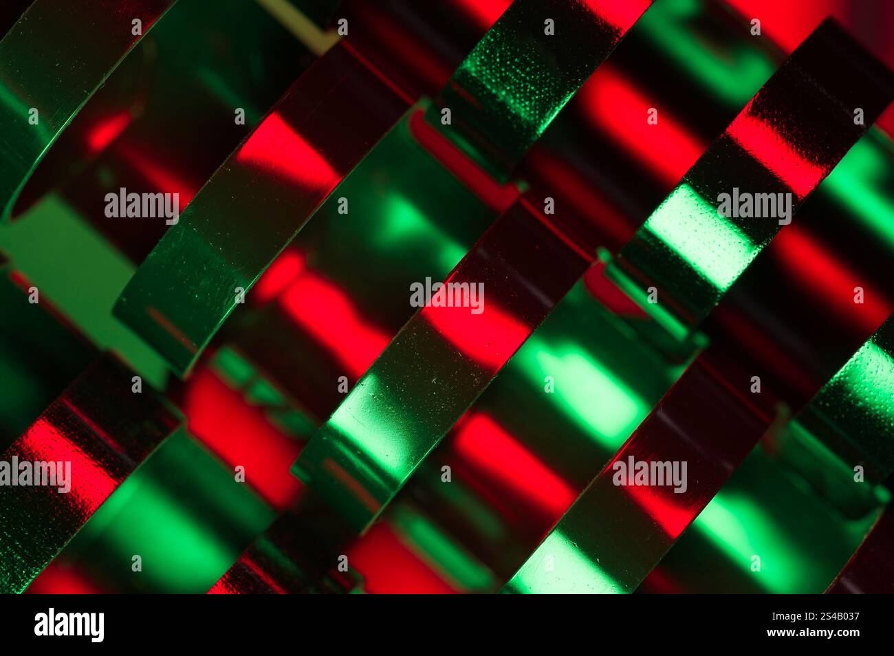 Primo piano astratto di anelli leganti in plastica con riflessi di rosso e verde Foto Stock