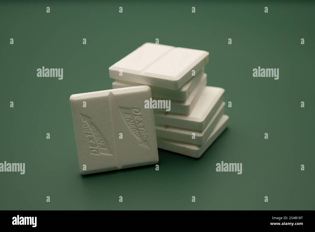 , Deutschland, 06.01.2025, Weiße Traubenzucker-Tabletten sind ordentlich gestapelt und auf einem Grünen Hintergrund präsentiert. Simbolo Perfekt als f Foto Stock