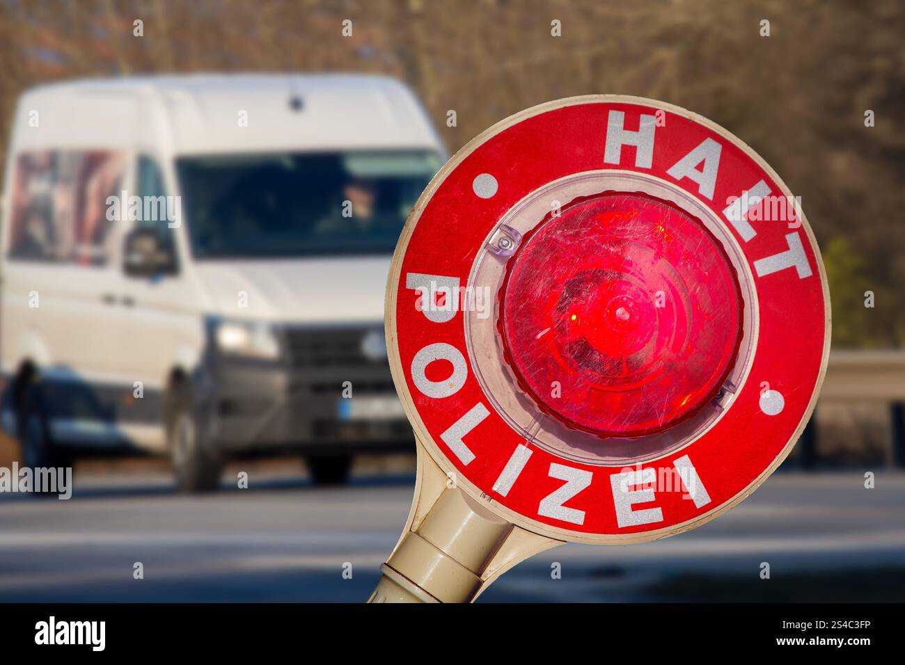 Controllo di polizia (Germania): Primo piano di una cazzuola di polizia con l'iscrizione HALT POLIZEI (Stop Police) di fronte a un furgone (composizione) Foto Stock Controllo di polizia (Germania): Primo piano di una cazzuola di polizia con l'iscrizione HALT POLIZEI (Stop Police) di fronte a un furgone (composizione) Foto Stock