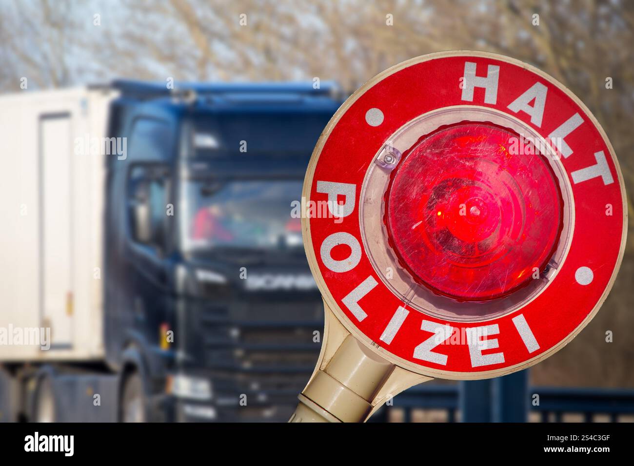 Controllo di polizia (Germania): Primo piano di una cazzuola di polizia con l'iscrizione HALT POLIZEI (Stop Police) di fronte a un camion (composizione) Foto Stock Controllo di polizia (Germania): Primo piano di una cazzuola di polizia con l'iscrizione HALT POLIZEI (Stop Police) di fronte a un camion (composizione) Foto Stock