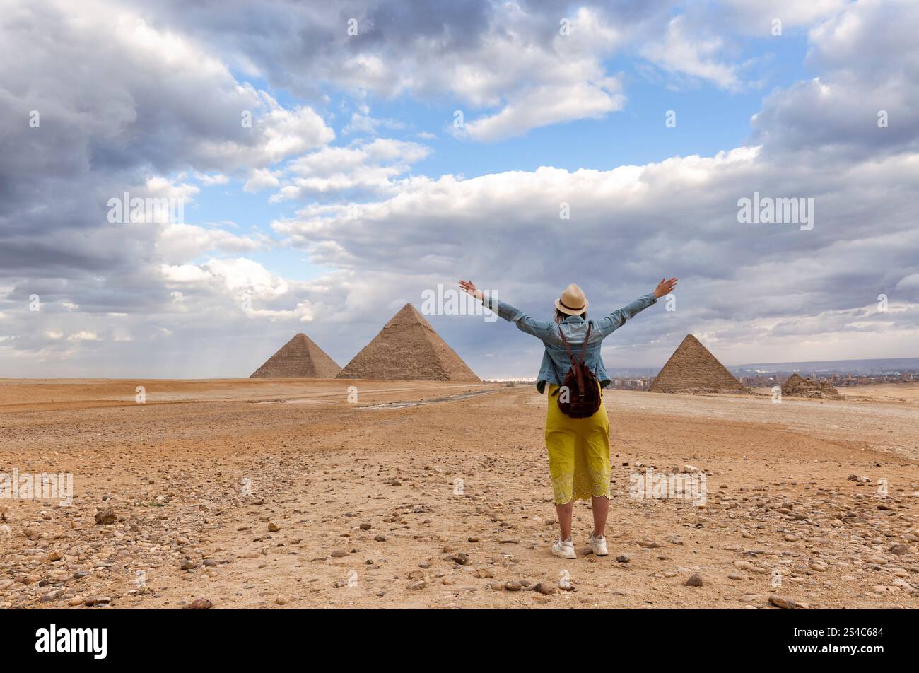 Vista posteriore di una donna che indossa un cappello, guardando le 3 grandi piramidi in Egitto Foto Stock