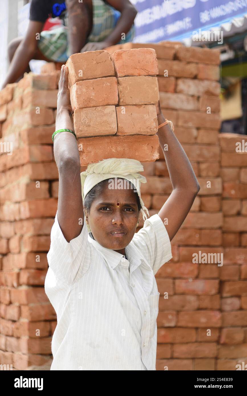 Kanchipuram, Tamil Nadu, India meridionale, India, Asia, donna che porta mattoni sulla testa, scena di tutti i giorni per strada, in Asia Foto Stock