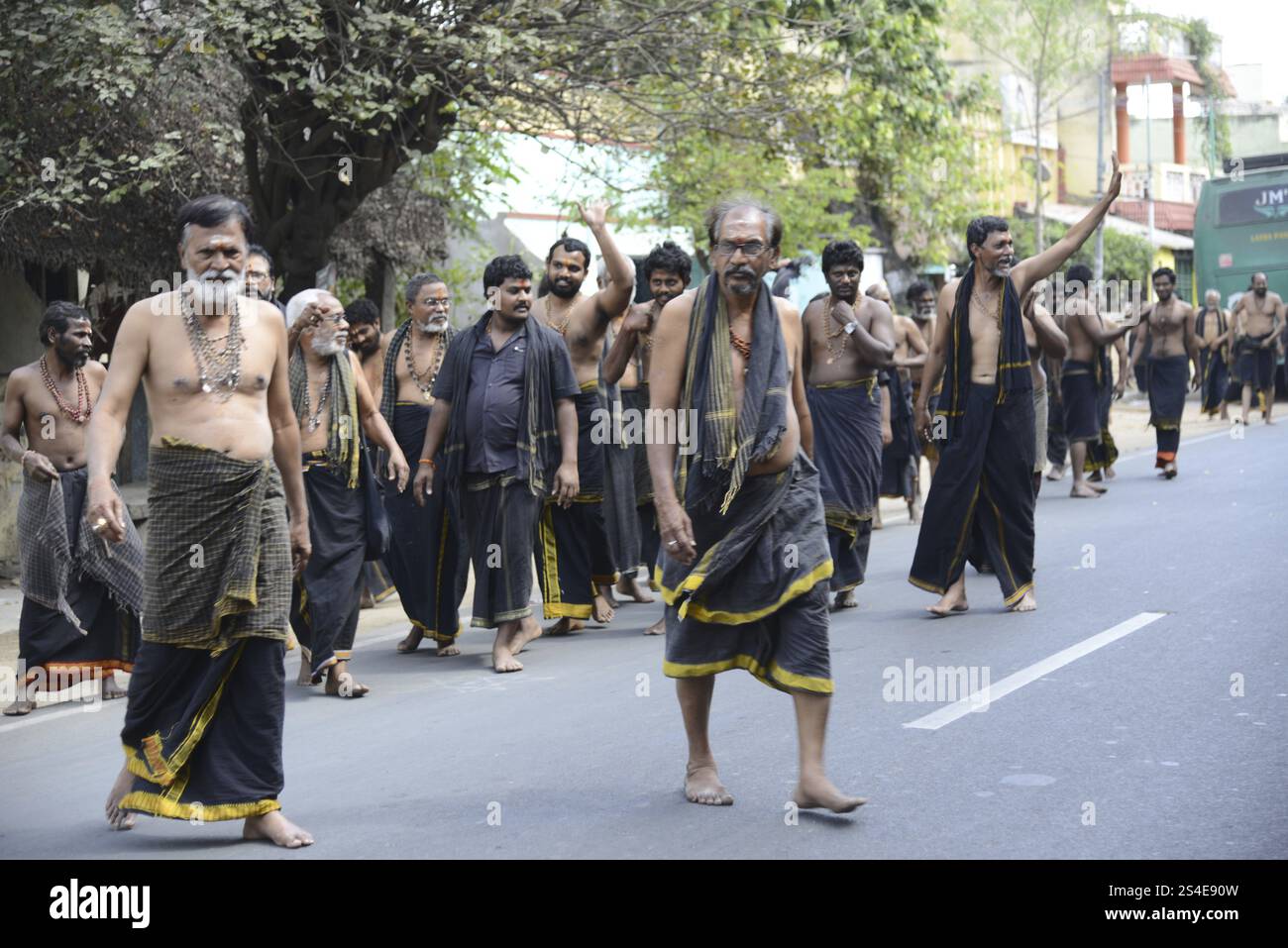 Pellegrini, devoti in viaggio verso il tempio Vishnu Varadaraja, Kanchipuram, uomini in abito tradizionale durante una processione su una strada, Kanchipuram, T. Foto Stock
