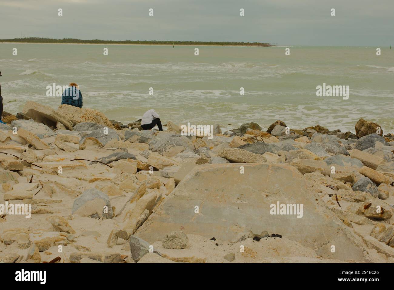 St. Pete Beach, Florida, Pass-a-Grille Beach Vista a sud su grandi rocce, molte persone verso Shell Key Island. Nel tardo pomeriggio, nuvoloso. Foto Stock