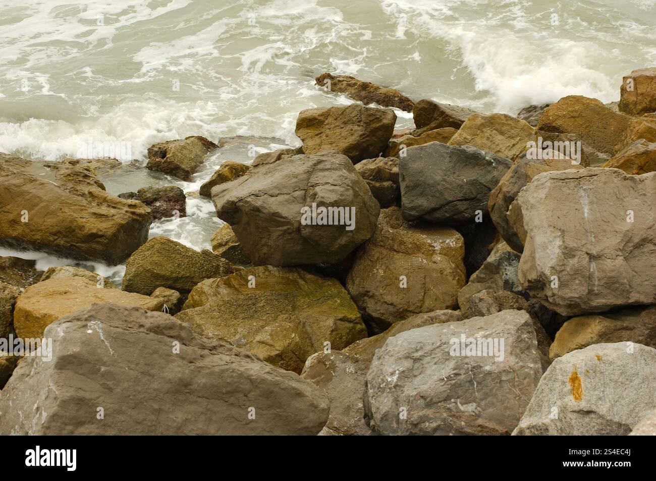 Ammira le grandi rocce di St. Pete Beach, Florida, Pass-a-Grille. Grandi onde bianche che si tuffano su e sopra grandi rocce. In una giornata nuvolosa. Roo Foto Stock
