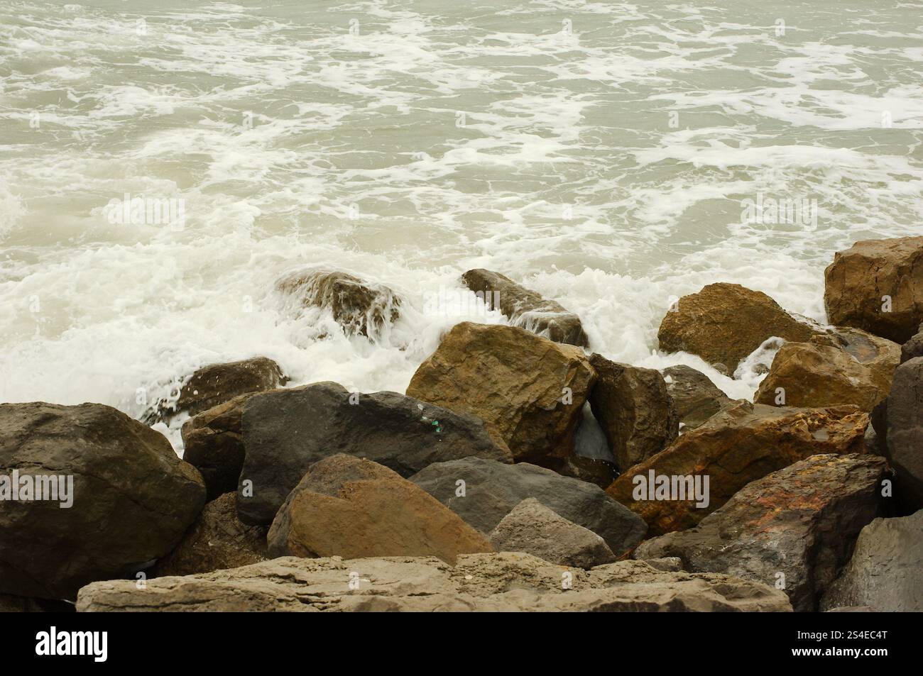 Ammira le grandi rocce di St. Pete Beach, Florida, Pass-a-Grille. Grandi onde bianche che si tuffano su e sopra grandi rocce. In una giornata nuvolosa. Roo Foto Stock