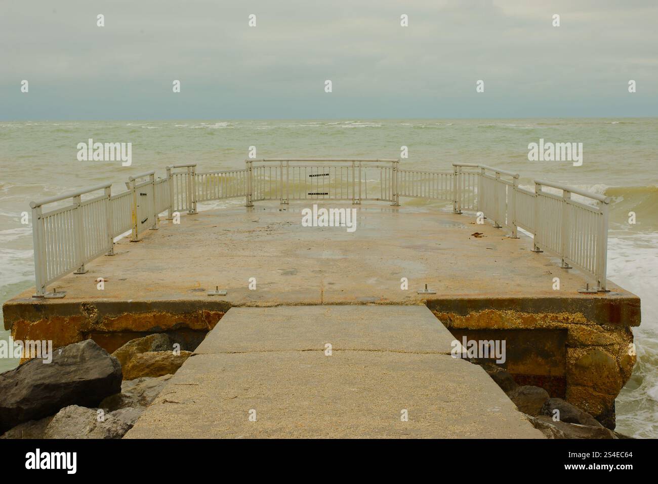 Ammira il Golfo del Messico, situato sul molo per la pesca di St. Pete Beach, Florida, USA. Pass-a-Grille. Grandi onde bianche che spruzzano sulla torta Foto Stock
