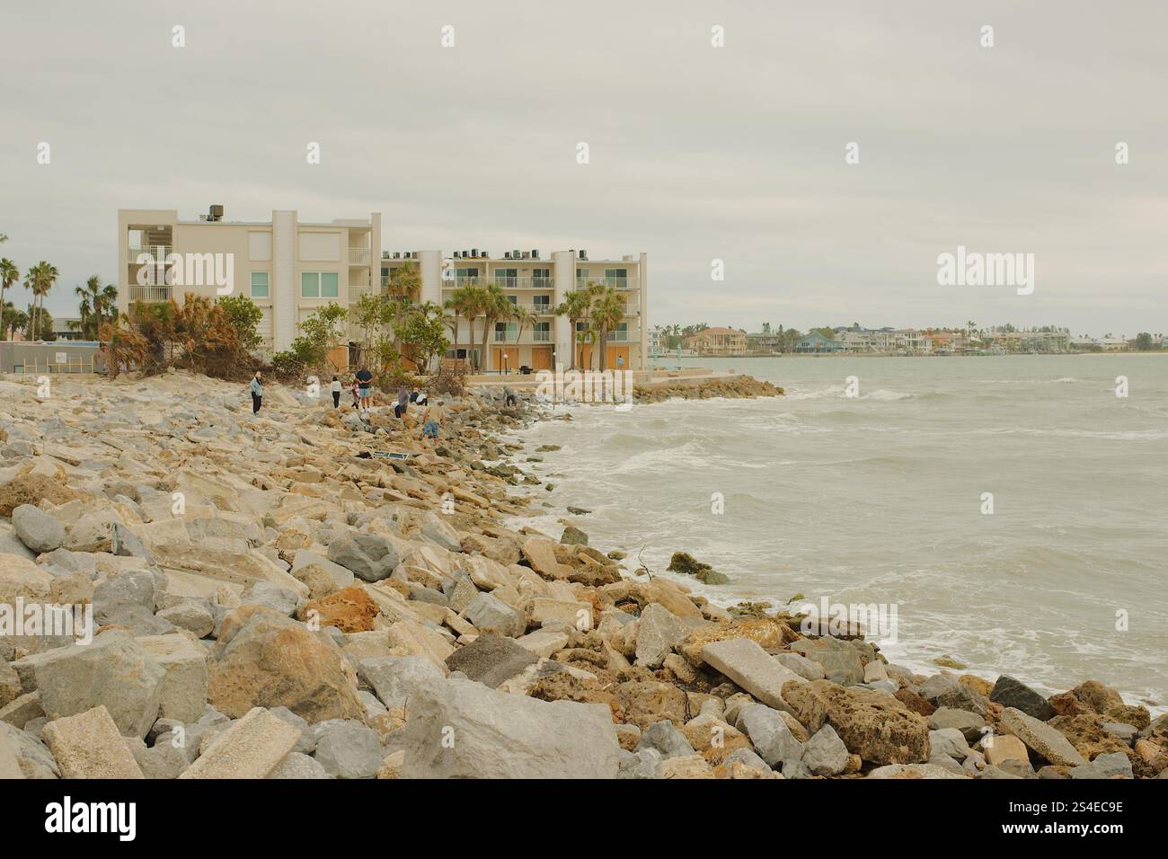 St. Pete Beach, Florida, Pass-a-Grille Beach Vista a sud su grandi rocce, molte persone verso Shell Key Island. Nel tardo pomeriggio, nuvoloso. Grande Foto Stock