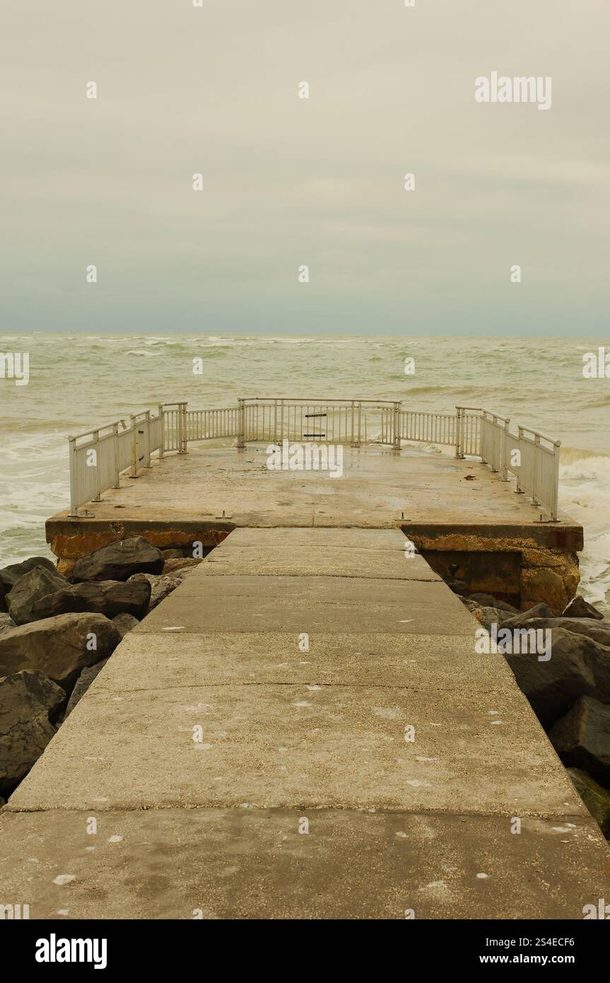 Ammira il Golfo del Messico, situato sul molo per la pesca di St. Pete Beach, Florida, USA. Pass-a-Grille. Grandi onde bianche che spruzzano sulla torta Foto Stock