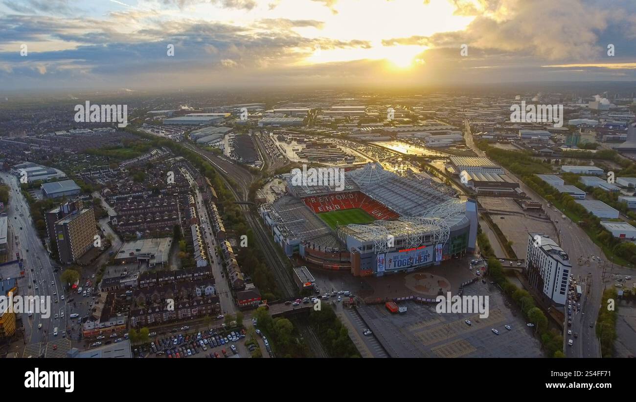 Incredibili riprese aeree dell'Old Trafford Stadium di Manchester, Inghilterra, circondato da paesaggi urbani e industriali al tramonto. Perfetto per lo sport Foto Stock
