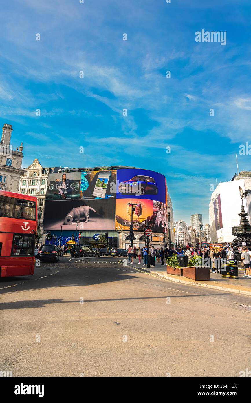 Una vivace scena da Trafalgar Square a Londra, con iconici cartelloni e un tradizionale autobus rosso a due piani Foto Stock