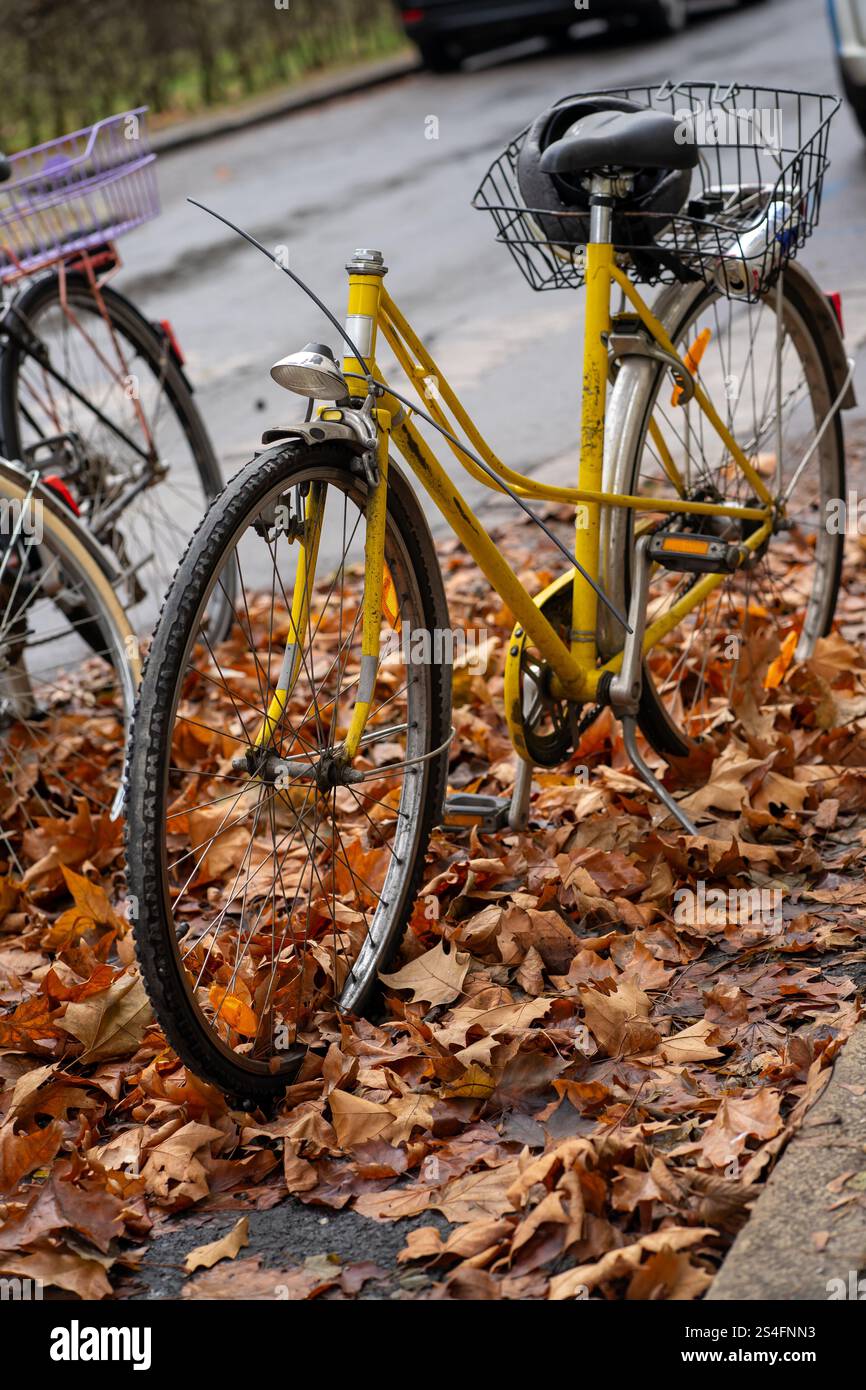 Vista di una bicicletta gialla rotta in piedi in un parcheggio Foto Stock