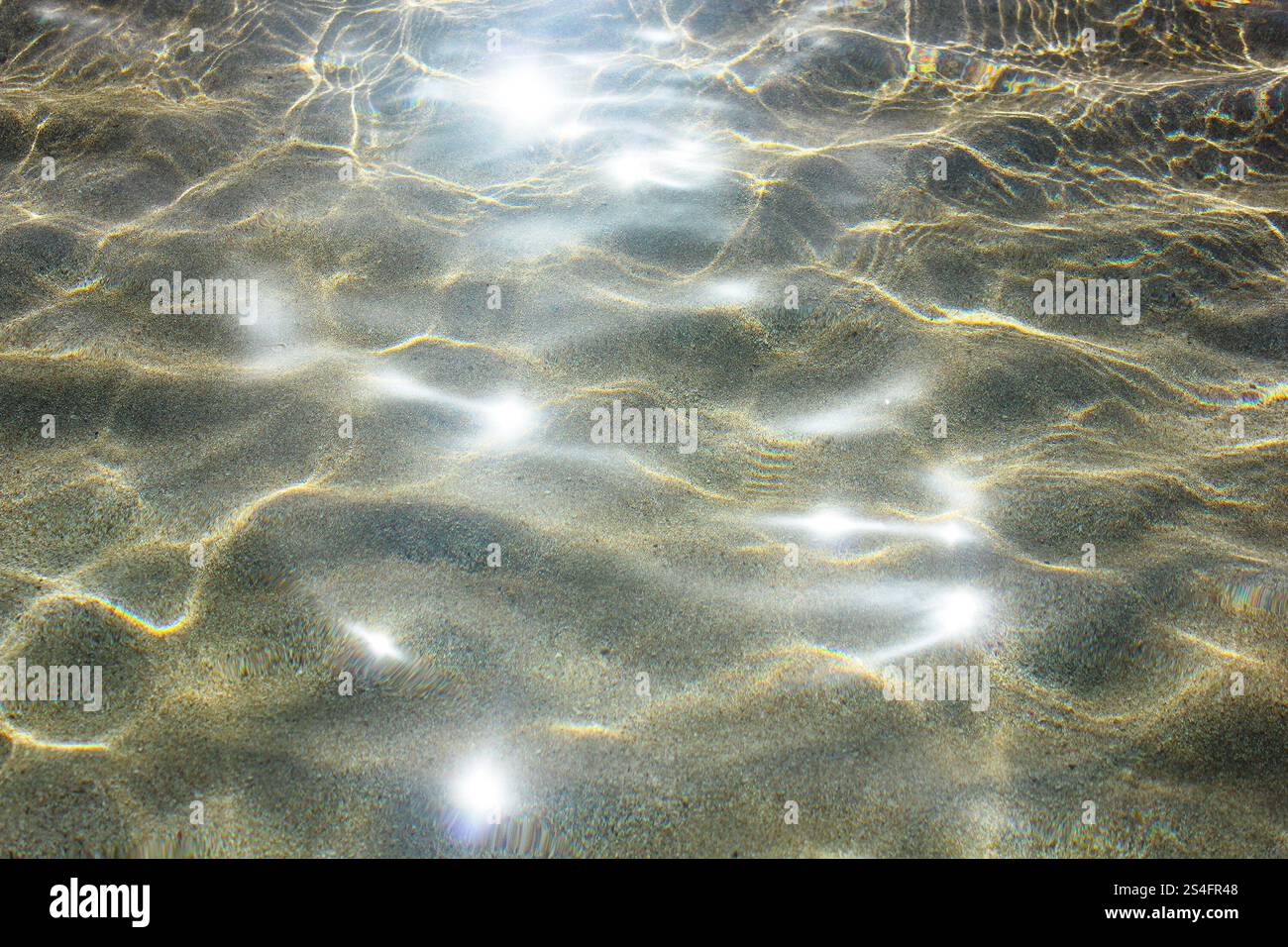 Splendida superficie d'acqua marina lucida con riflessi di luce solare e ombra sul fondo. Foto Stock