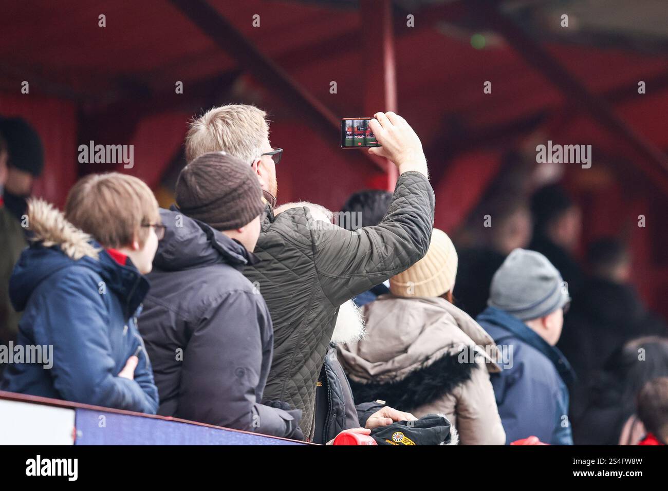 Tamworth domenica 12 gennaio 2025. Un tifoso di Tamworth registra i ricordi personali della giornata al telefono durante la partita del terzo turno della Coppa d'Emirati Arabi tra Tamworth e Tottenham Hotspur al Lamb Ground di Tamworth domenica 12 gennaio 2025. (Foto: Stuart Leggett | mi News) crediti: MI News & Sport /Alamy Live News Foto Stock