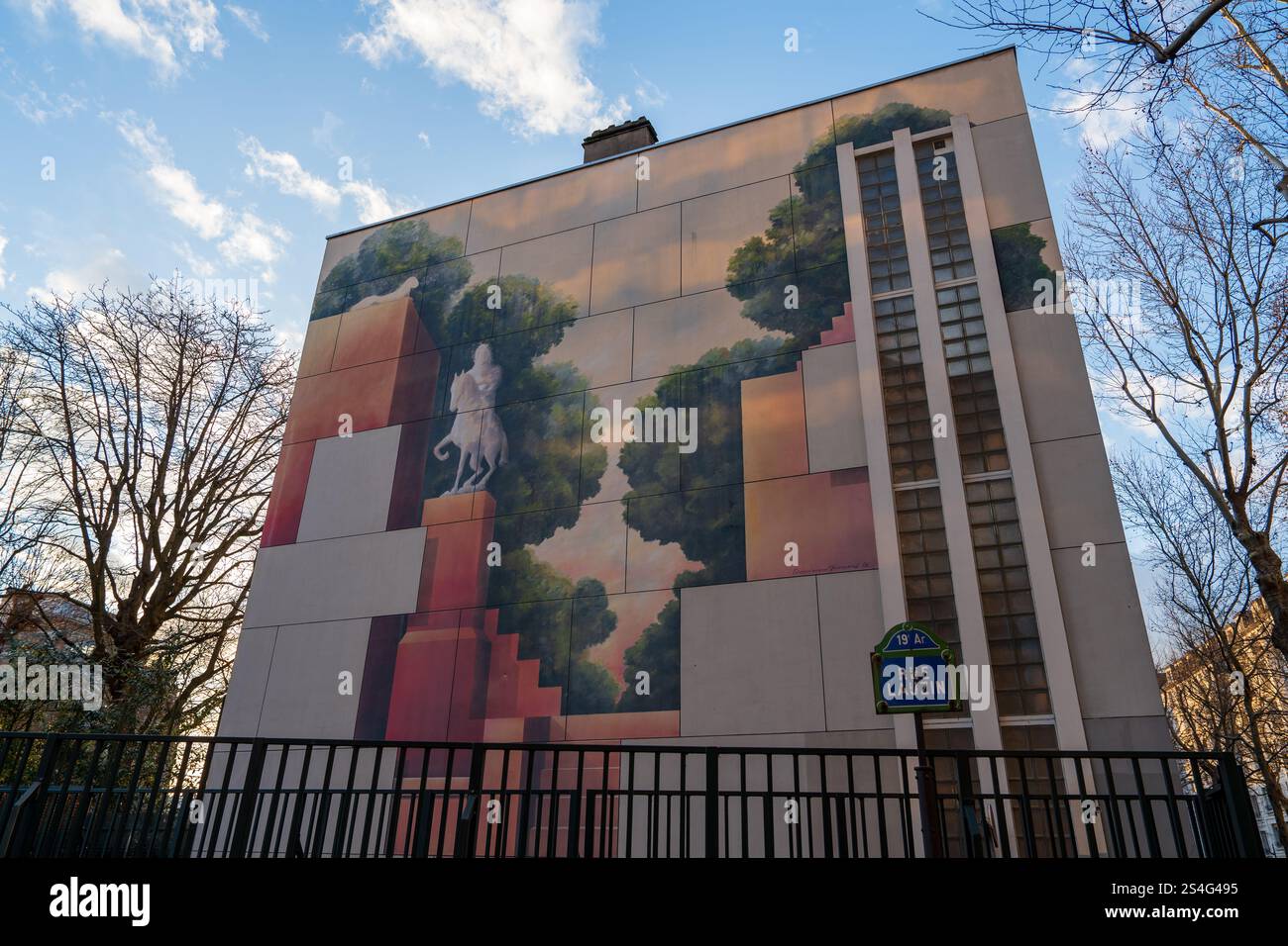 Murale urbano che raffigura una figura tra alberi stilizzati al tramonto Foto Stock