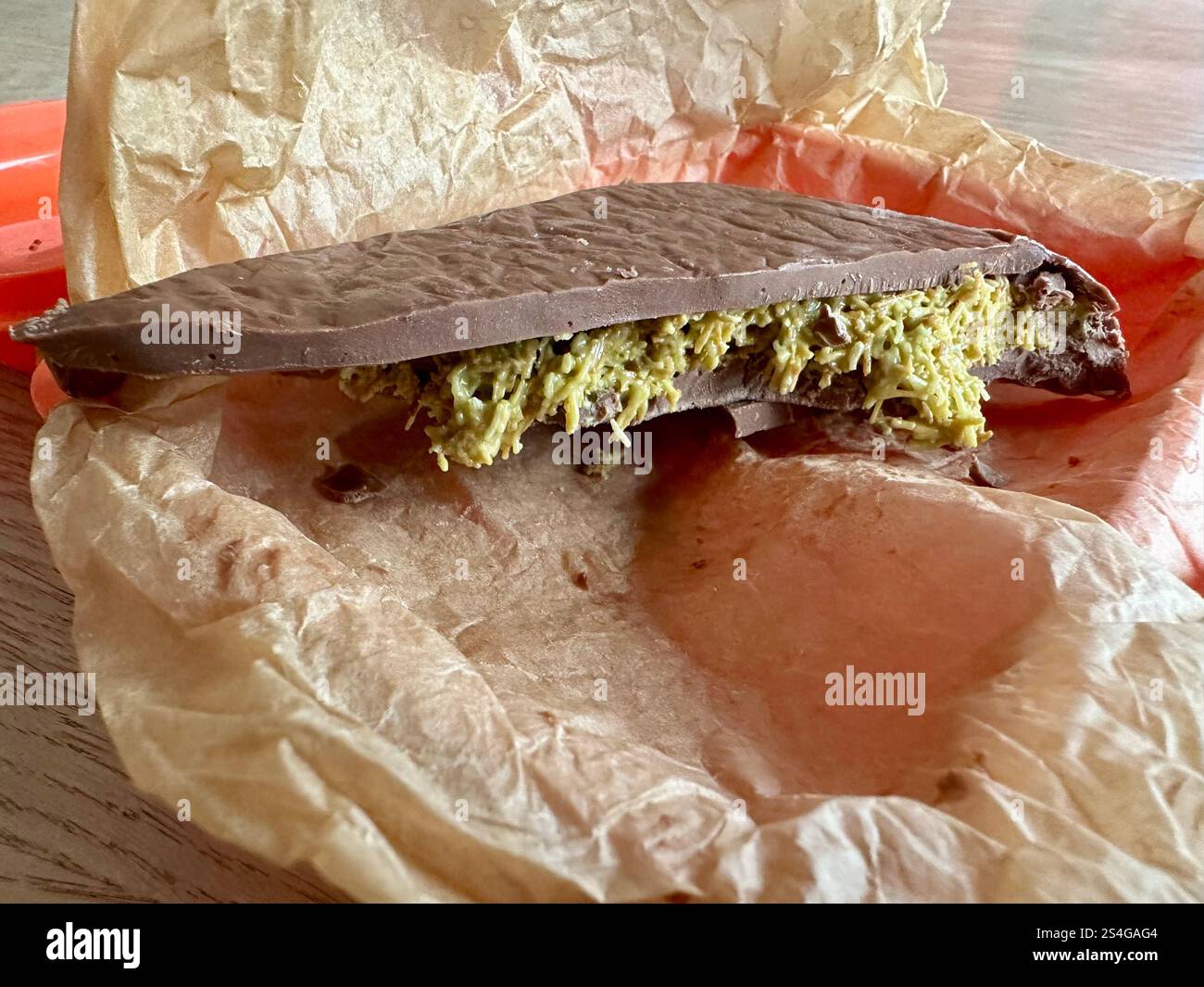 Cioccolato di Dubai fatto in casa in pergamena da forno in un cestino per pranzo all'arancia - Immagine stock catturata con smartphone