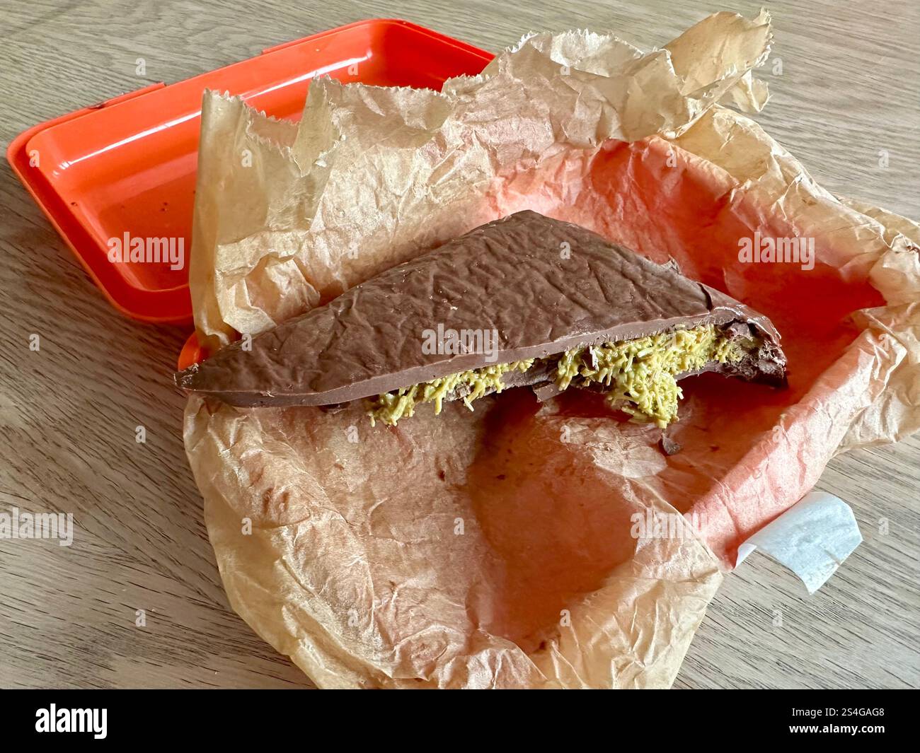 Cioccolato di Dubai fatto in casa in pergamena da forno in un cestino per pranzo all'arancia - Immagine stock catturata con smartphone