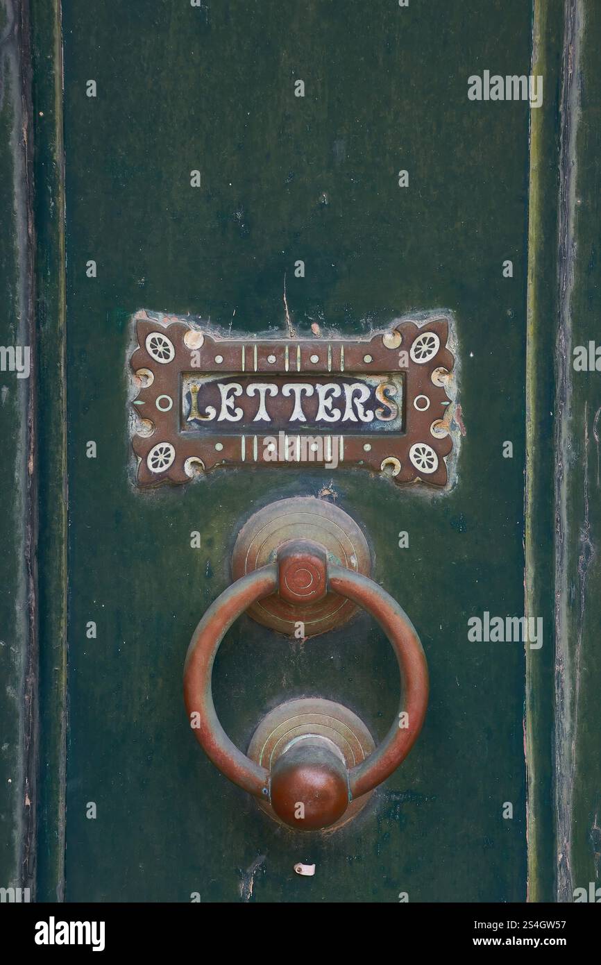 Porta vintage verde con slot decorativo per lettere e battitacco circolare Foto Stock