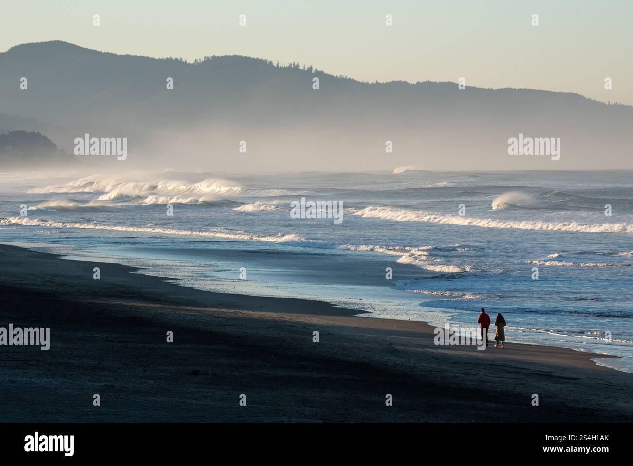 Una coppia che cammina a Kiwanda Beach, Oregon. Foto Stock