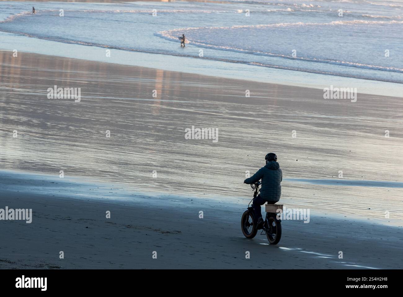 Uomo in sella a una bicicletta elettrica a Kiwanda Beach, Oregon. Foto Stock