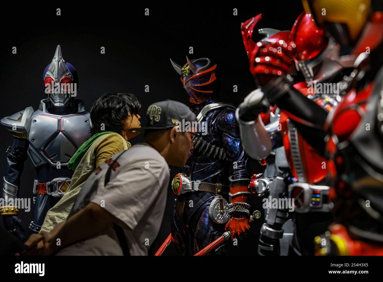 Un fan della serie drammatica Kamen Rider scatta una foto con la replica di Kamen Rider durante la Kamen Rider 50th Anniversary Exhibition a Kuala Lumpur, Malesia, il 12 gennaio 2025. La mostra celebra la leggendaria serie di supereroi giapponesi che affascina i fan da generazioni. Oltre 50 repliche a grandezza naturale di Kamen Riders e oggetti di scena delle epoche Showa, Heisei e Reiwa del franchise danno vita ai personaggi di Kamen Rider attraverso costumi originali, oggetti di scena iconici e pannelli manga riprodotti. (Foto di Hari Anggara/NurPhoto) Foto Stock