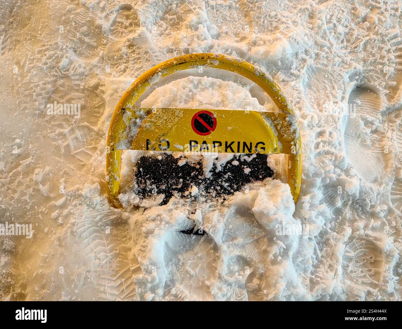 Lucchetto giallo in metallo: Parcheggio non disponibile, coperto di neve di notte Foto Stock