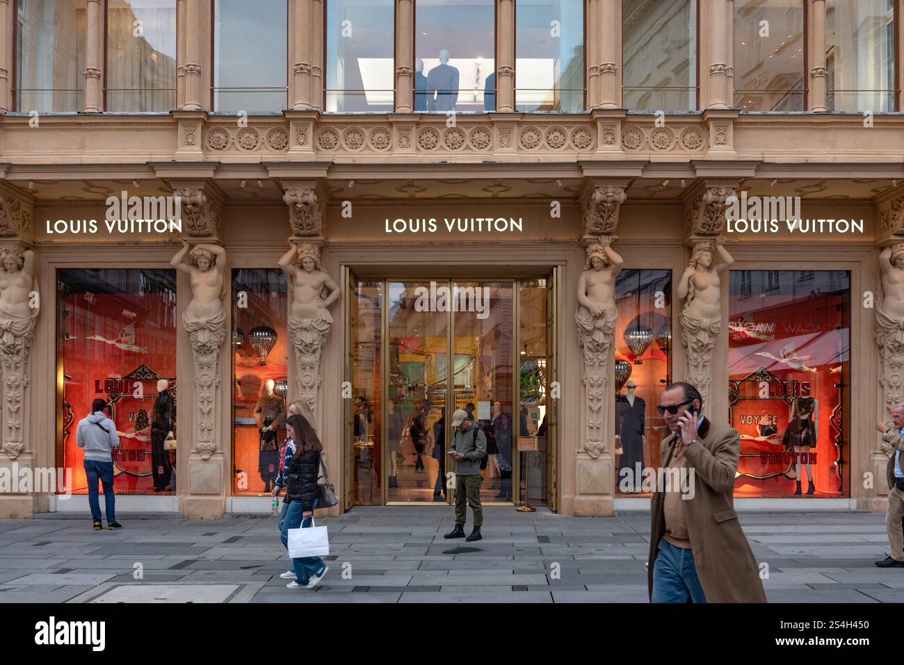 Gli acquirenti fuori dal negozio alla moda Louis Vuitton, un marchio di lusso che vende borse e regali di moda, Vienna, Austria, Europa. Foto Stock