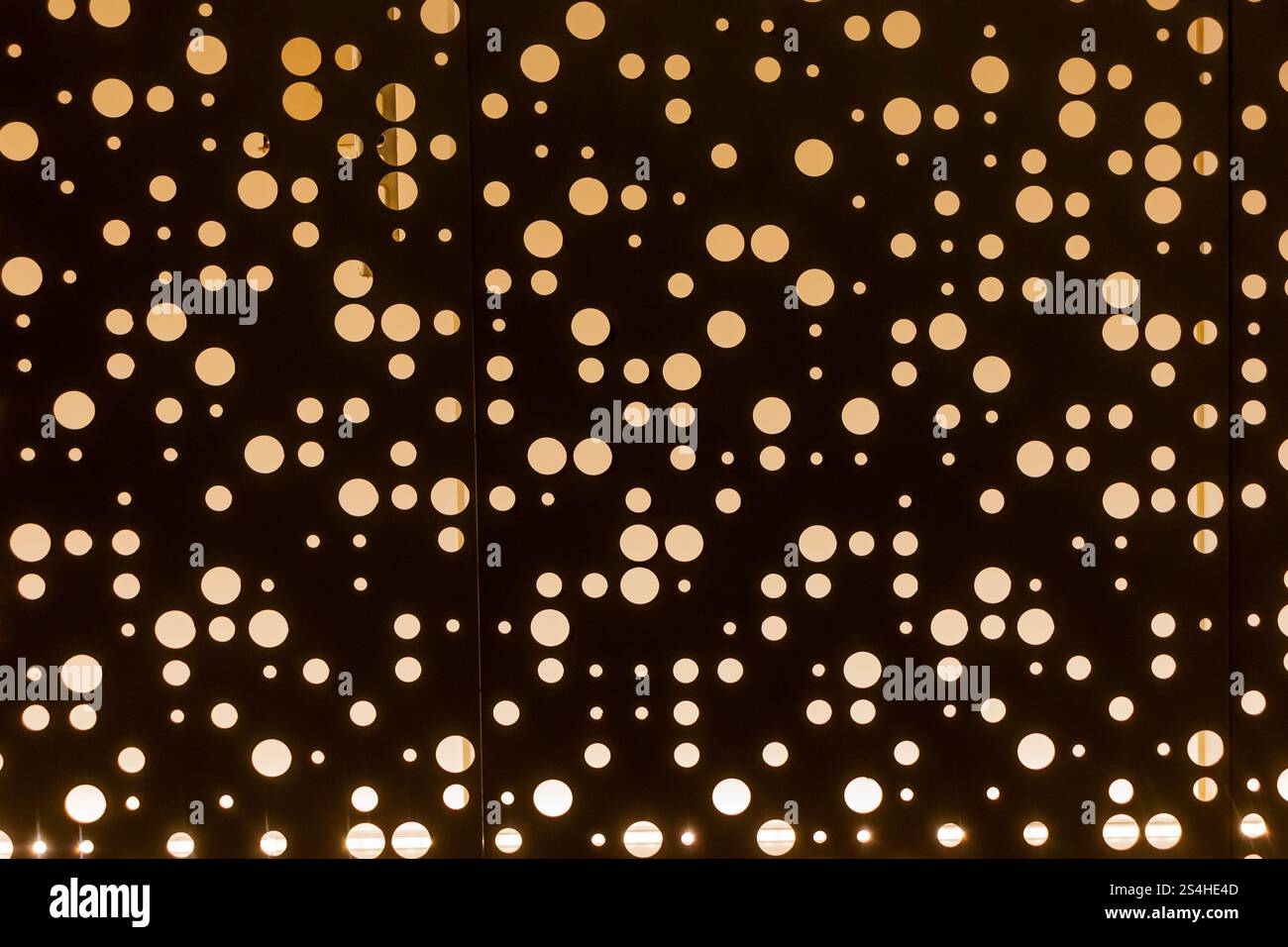 Modello astratto moderno con elementi circolari illuminati su superficie scura Foto Stock