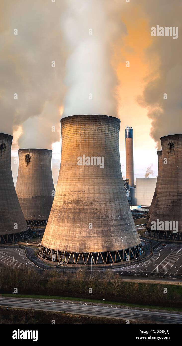 Vista aerea verticale di un gruppo di torri di raffreddamento in una centrale a carbone con emissioni di anidride carbonica in un concetto di aria sporca o inquinata Foto Stock
