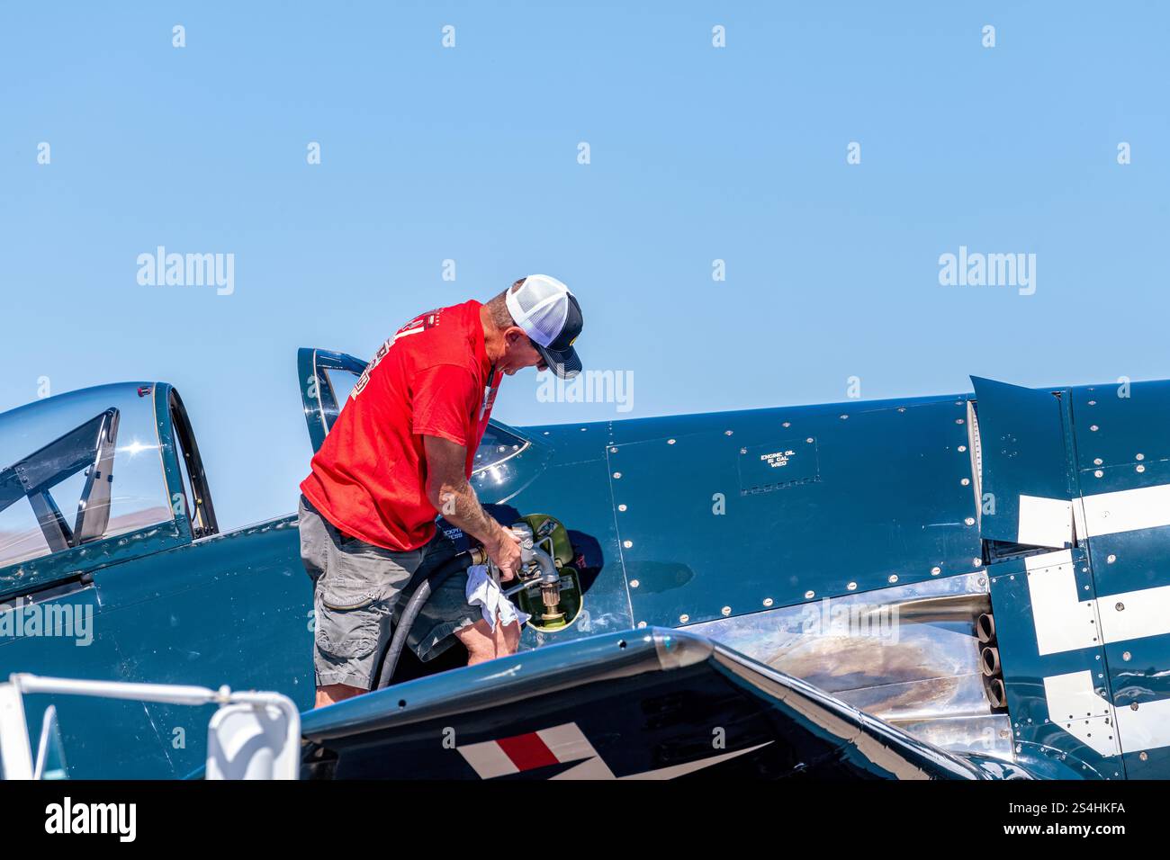 L'uomo aggiunge gas a un aereo blu Foto Stock