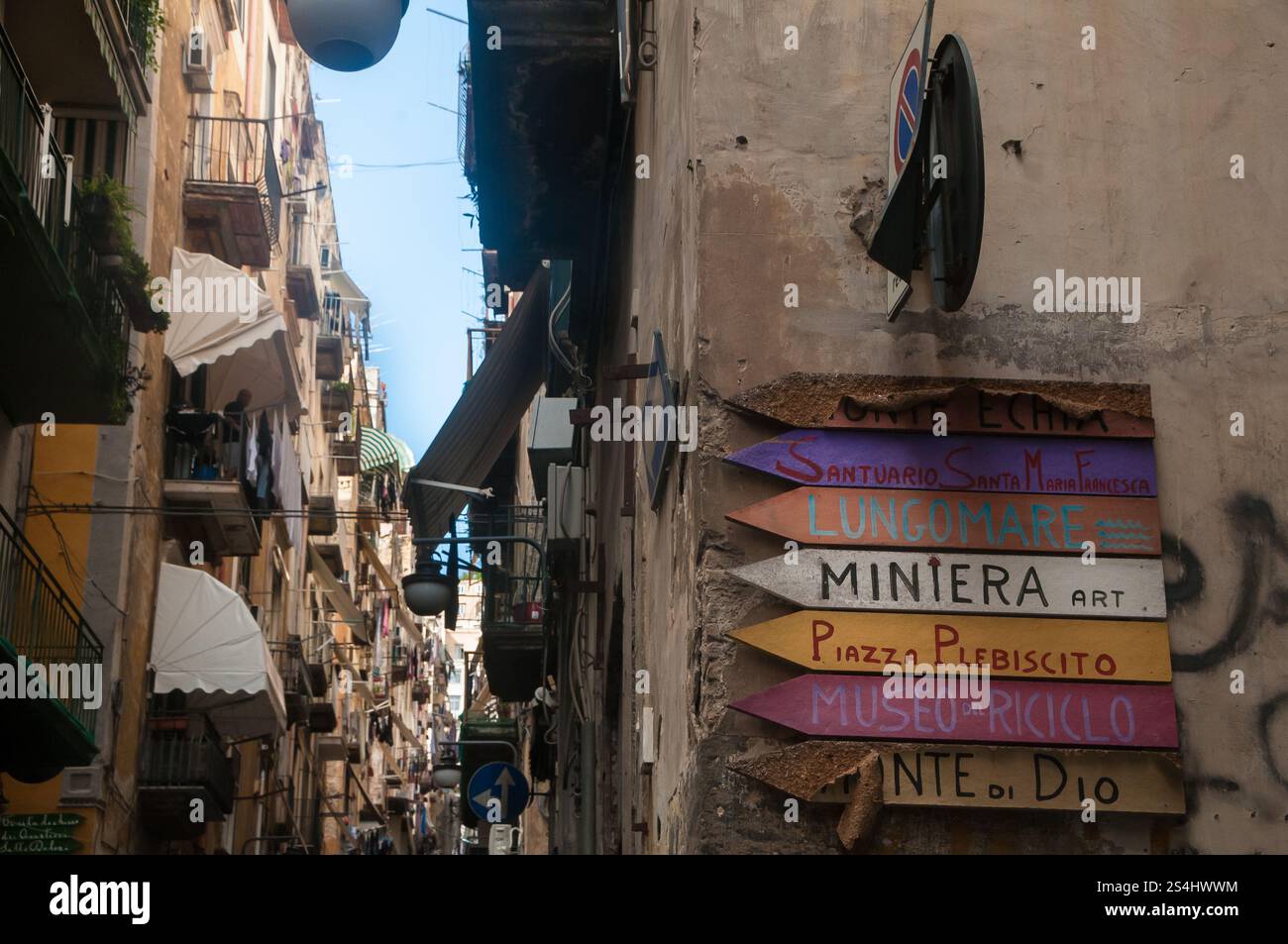Scorcio dei quartieri spagnoli con cartelli stradali artigianali e indipendenti realizzati con legno riciclato dall'artista e artigiano Salvatore Iodice. Foto Stock