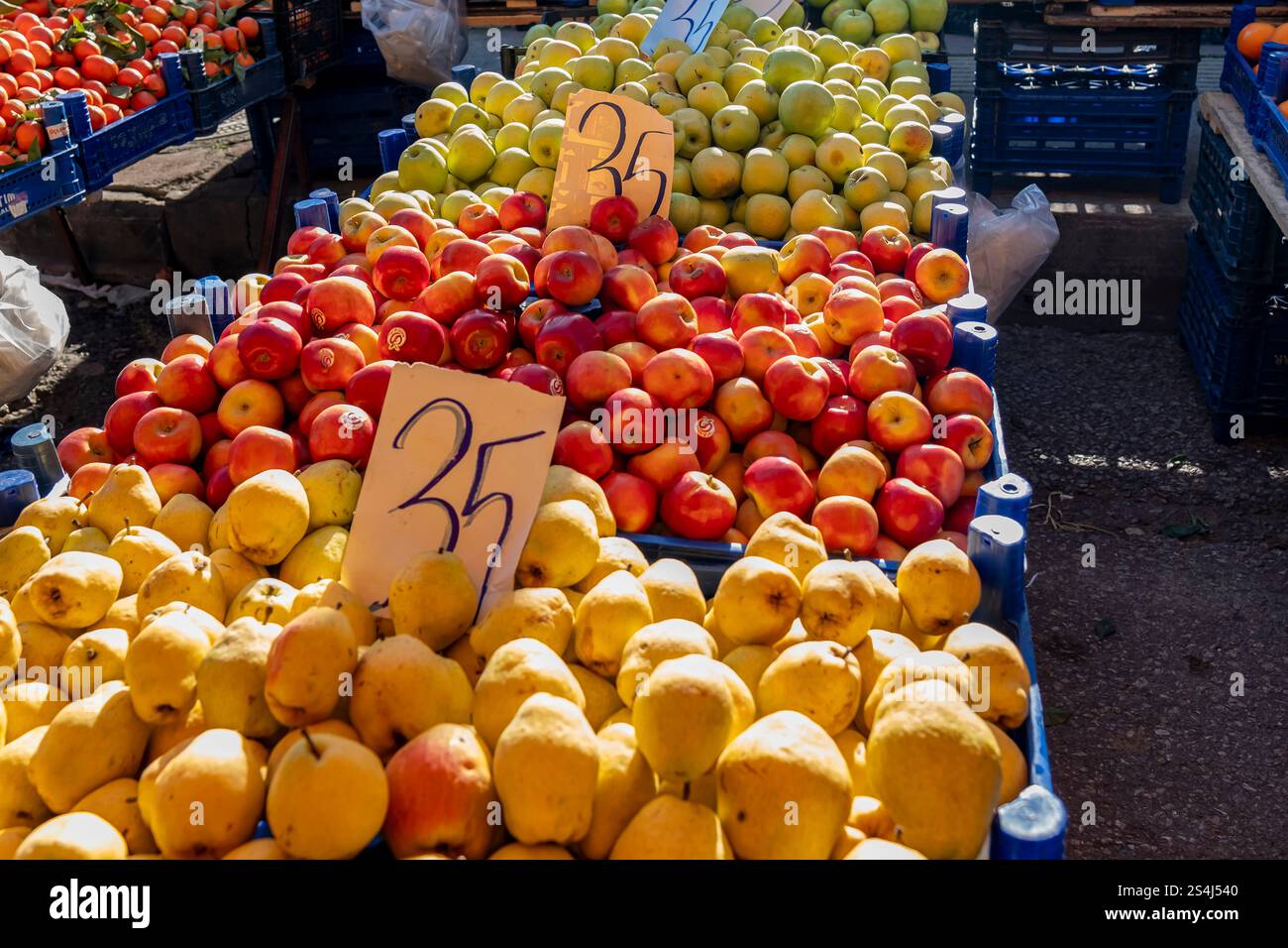Un grande mucchio di mele e arance è in mostra in un mercato. Le mele sono numerate 35, 36, 37, 38, 39, 40, 41, 42, 43, 44, 45, 46, 47, 48, 49, 50 Foto Stock