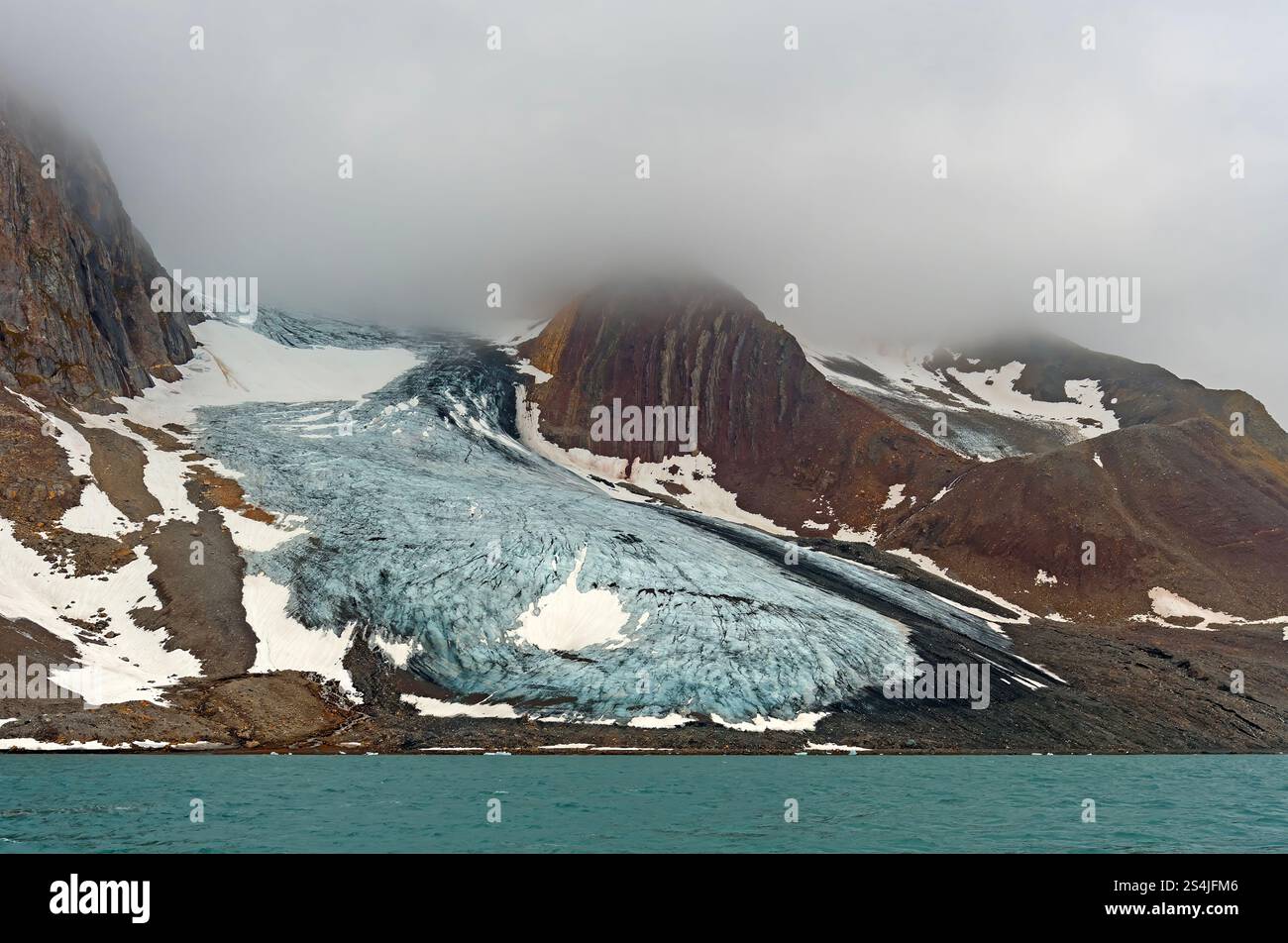 Ritiro del ghiacciaio su un'isola montuosa a Hornsund nelle isole Svalbard Foto Stock