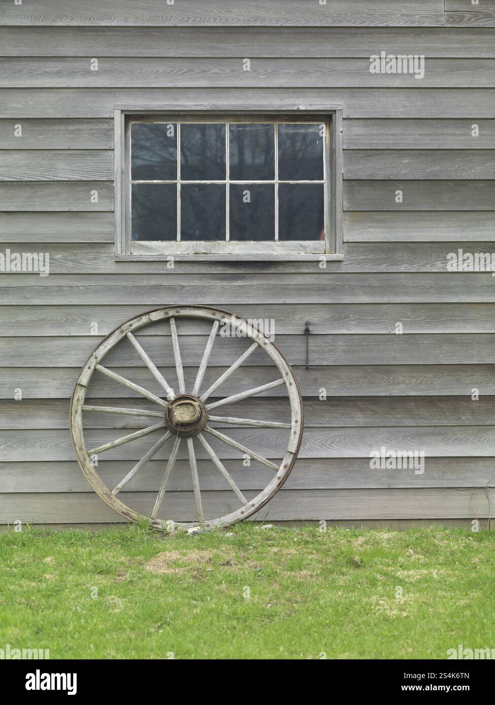 In legno antico ruota carrello sostennero contro il muro del granaio. Ontario in Canada. Foto Stock