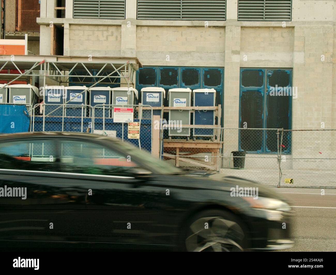 Solo per uso editoriale 12 gennaio 2025 St. Petersburg, Florida, USA. Guarda dall'altra parte della strada con un'auto nera sfocata che passa da sinistra a destra. Verso un edificio Foto Stock