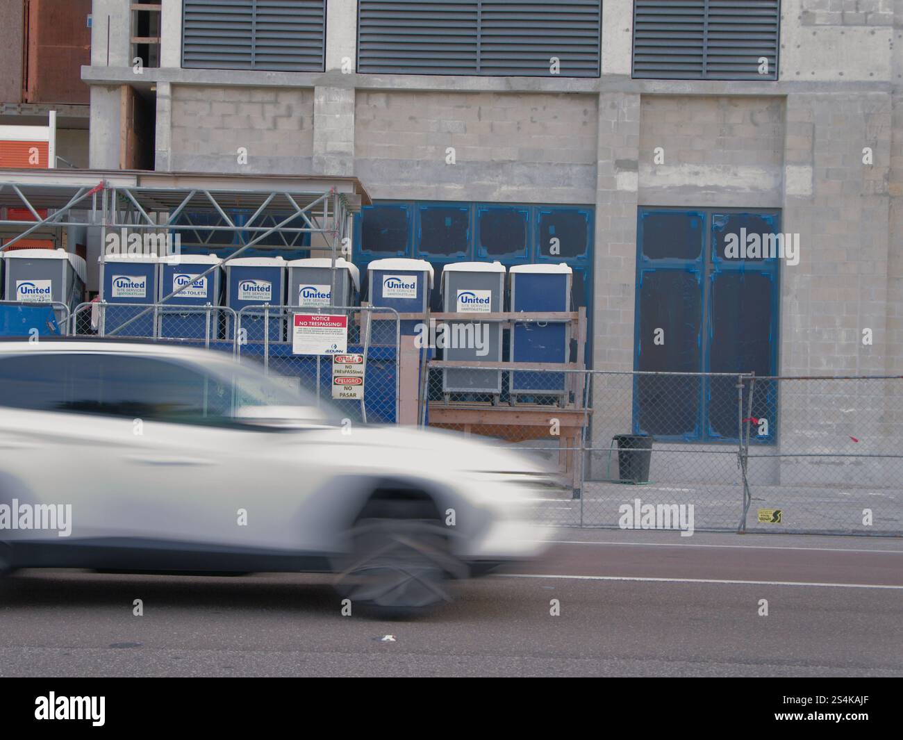 Solo per uso editoriale 12 gennaio 2025 St. Petersburg, Florida, USA. Guarda dall'altra parte della strada con un'auto bianca sfocata che passa da sinistra a destra. Verso un edificio Foto Stock