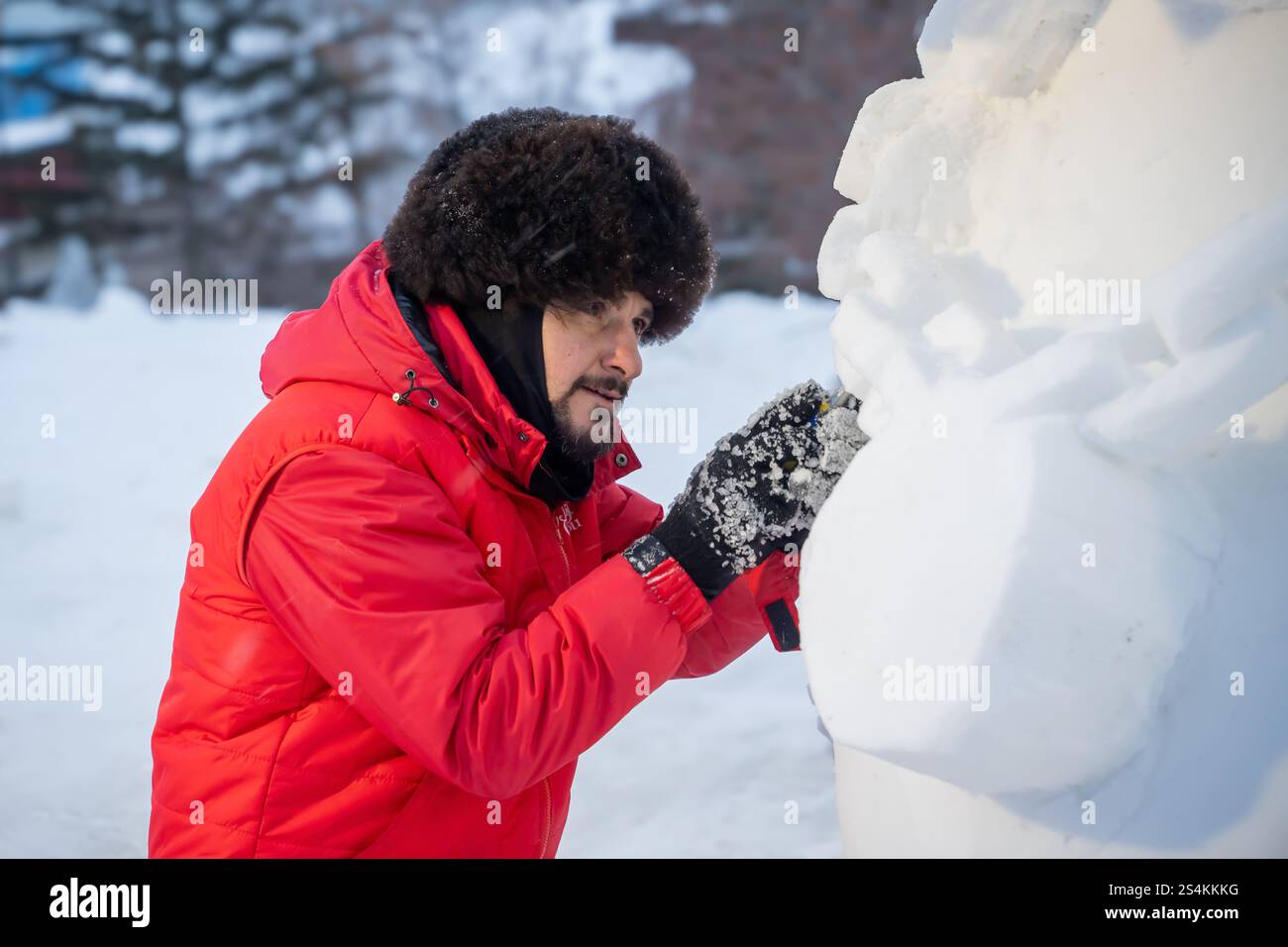 L'autore è uno scultore che fa elementi di una scultura di un maneggio nella mattina d'inverno in via Krasnoyarsk, Russia, 11 gennaio 2025. Scultura di ghiaccio Foto Stock