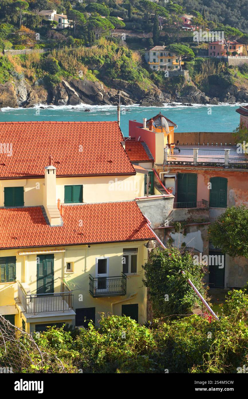Tetto di casa vicino al mare in Liguria. Edifici cittadini nelle giornate di sole. Viaggi, attrazioni e vacanze in Italia Foto Stock