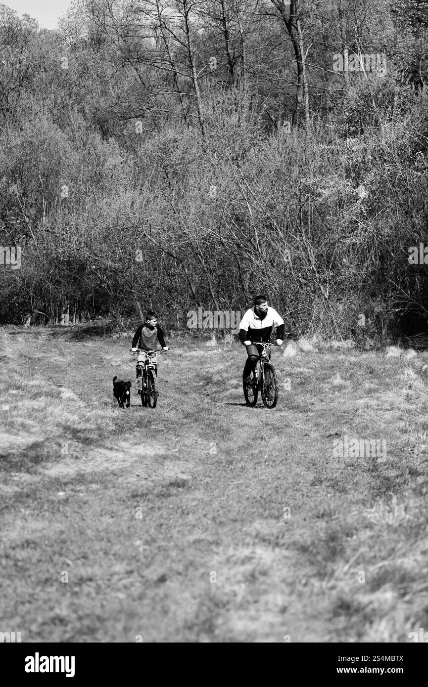 Padre e figlio in bicicletta sul campo. Attività ricreative in natura con la famiglia. Foto Stock