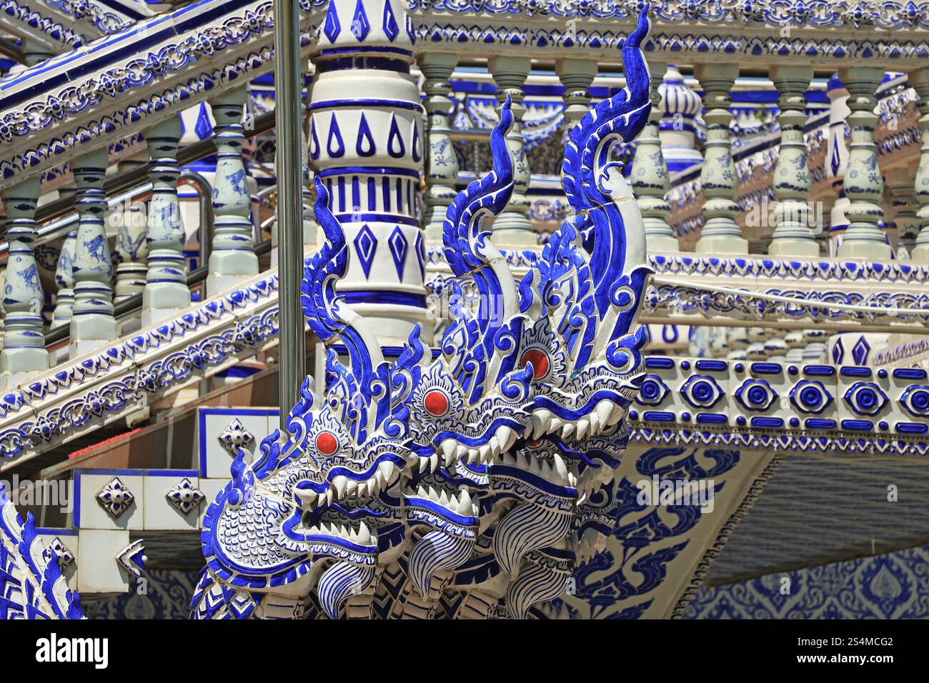 Fantastiche sculture in ceramica blu e bianca di Naga e le balaustre di Wat Pak Nam Khaem Nu o il Tempio Blu di Chanthaburi, Thailandia Foto Stock