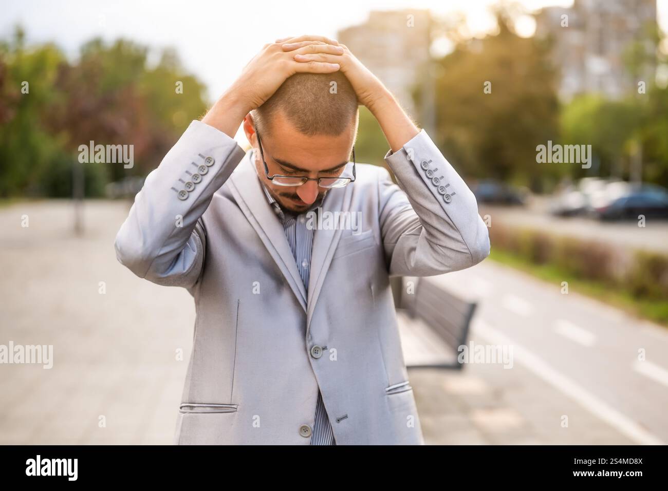 Ritratto di un giovane uomo d'affari ansioso e scontento che si trova in strada. Uomo d'affari esausto e deluso dopo il lavoro. Foto Stock