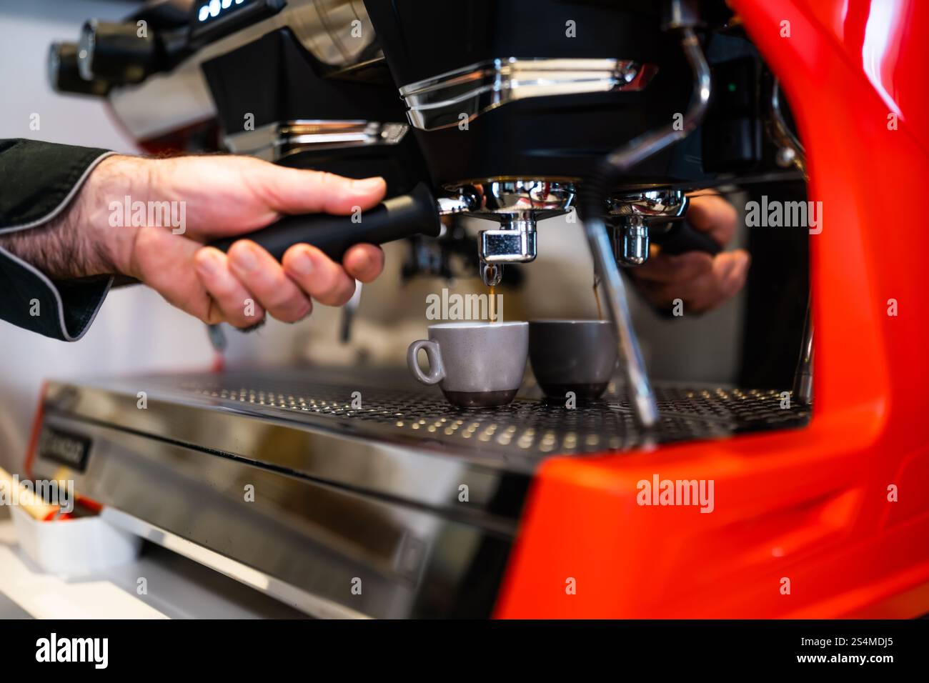Primo piano di un barista professionista che utilizza la macchina per caffè espresso. Foto Stock