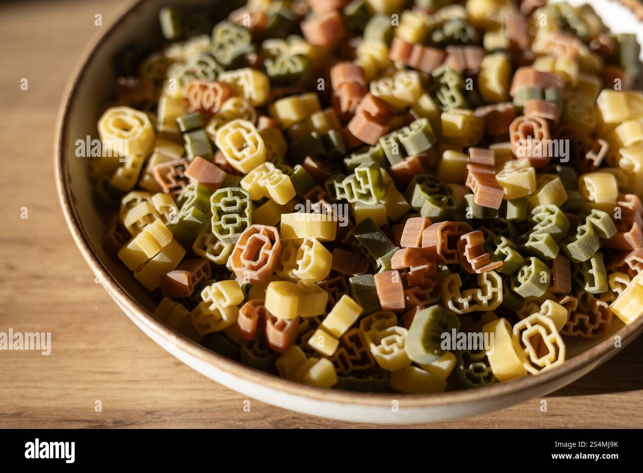 Una ciotola ripiena di pasta multicolore a forma di numeri con varie cifre. I numeri non sono abbastanza chiari per identificare un anno specifico. Foto Stock
